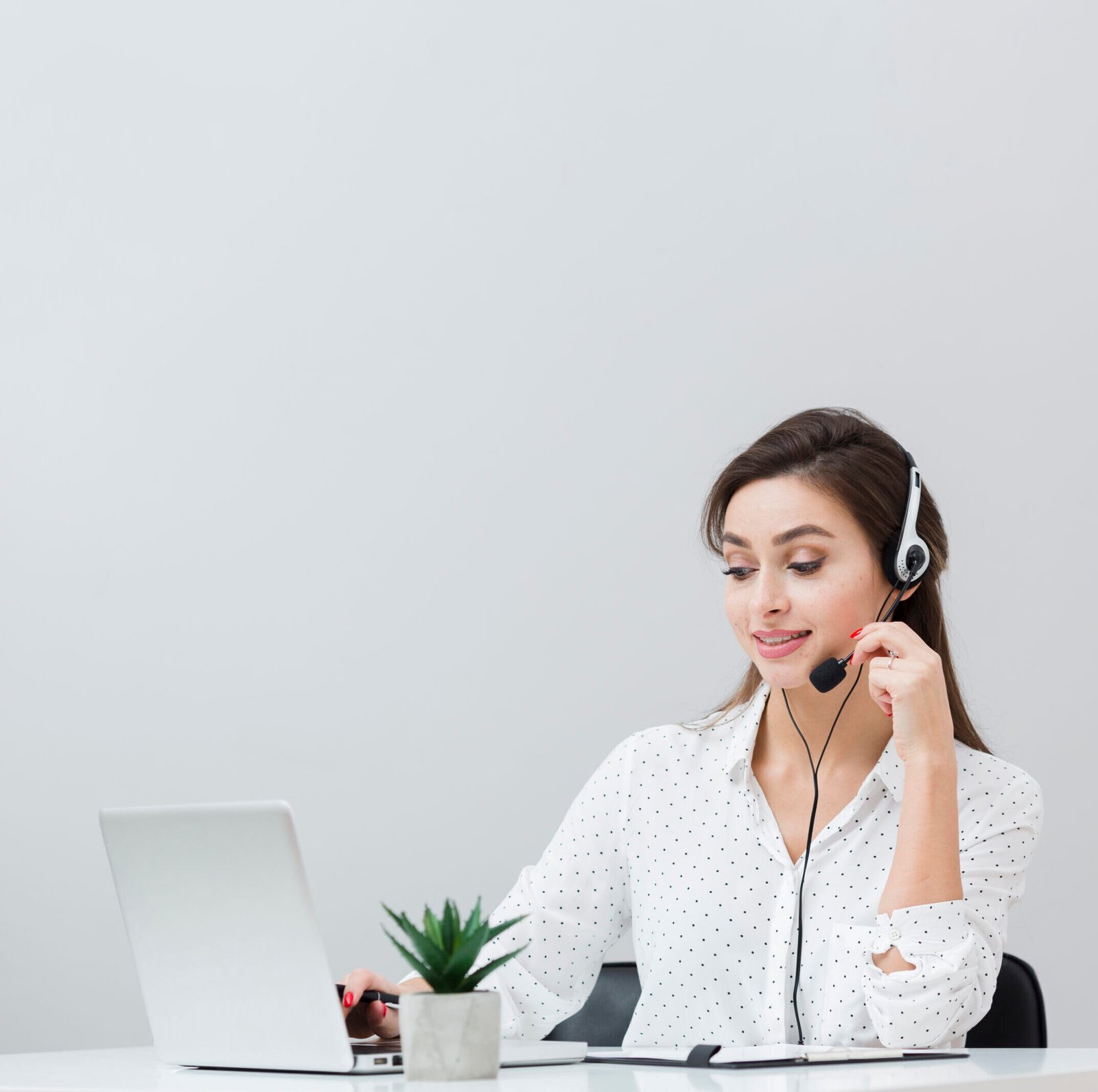 front-view-woman-working-desk-while-wearing-headset-looking-laptop